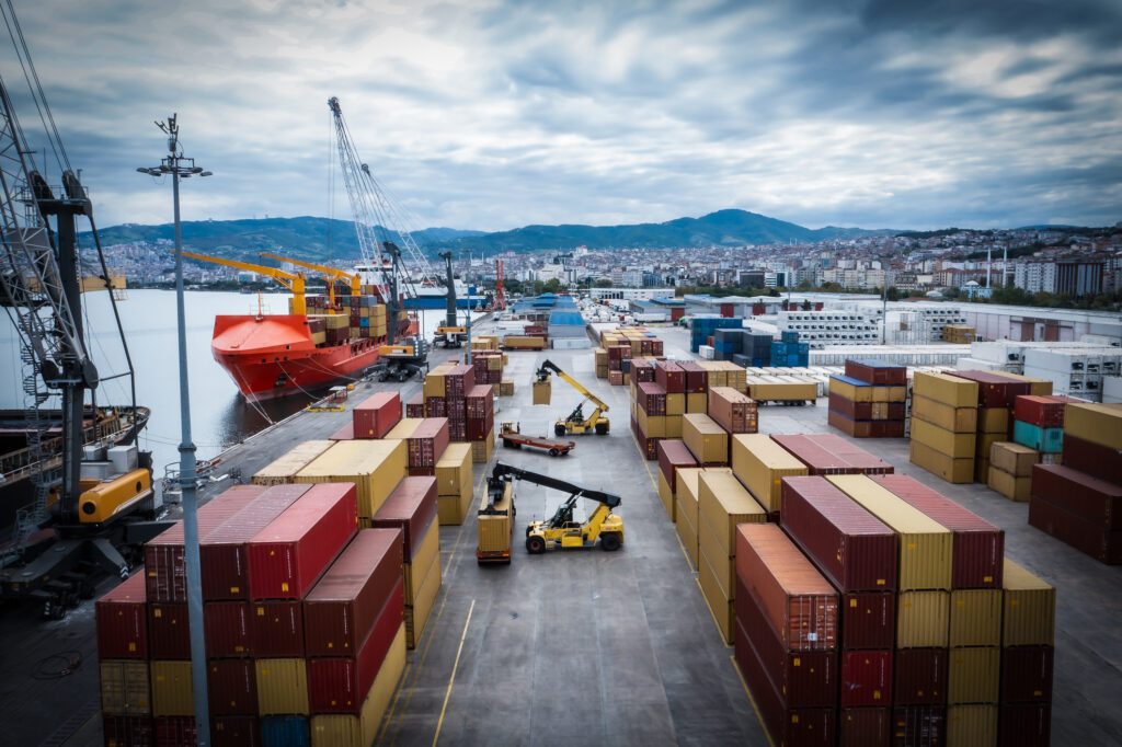 Aerial view of crane lifting up container in commercial port.